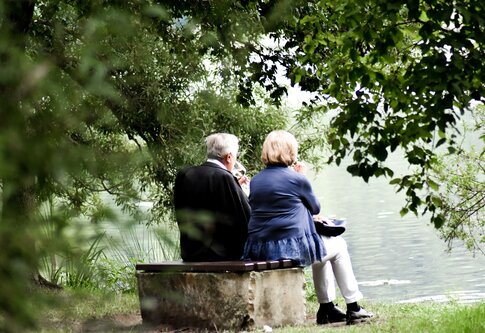 Un couple de personnes âgées est assis sur un banc au bord du lac.  | © unsplash