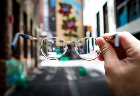 Une personne tient des lunettes. | © unsplash